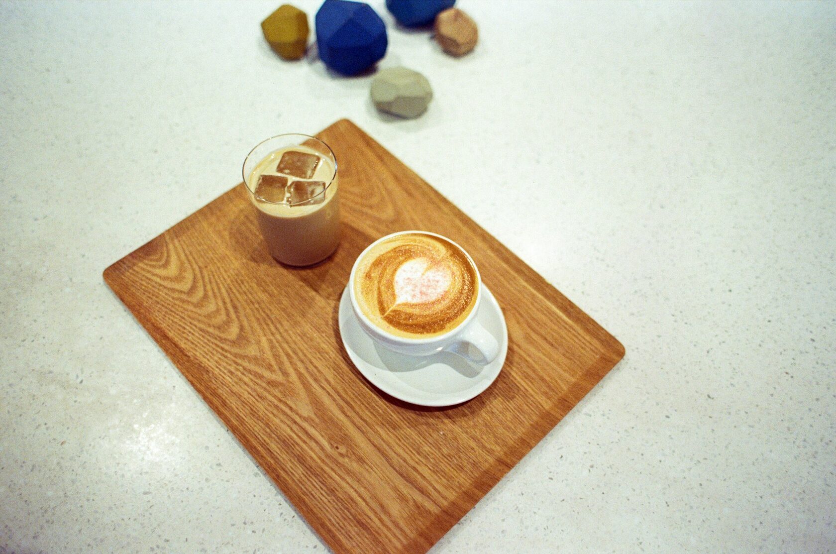 Latte art servido em chávena de cerâmica sobre mesa de madeira
